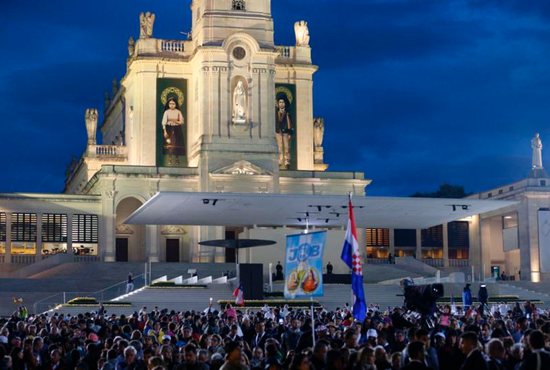 Banners showing Sts. Jacinta and Francisco Marto, two of the three Fatima seers, hang from the facade of the Basilica of Our Lady of the Rosary of Fatima as Pope Francis visits Portugal, May 12, 2017. In Nov. 29 remarks, Pope Francis encouraged rectors and workers at shrines to make guests feel "at home."