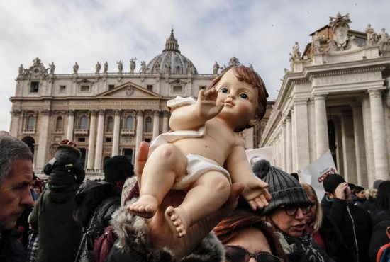 An audience member holds a figurine of baby Jesus as Pope Francis leads his Sunday Angelus prayer in St. Peter's Square at the Vatican Dec. 16.