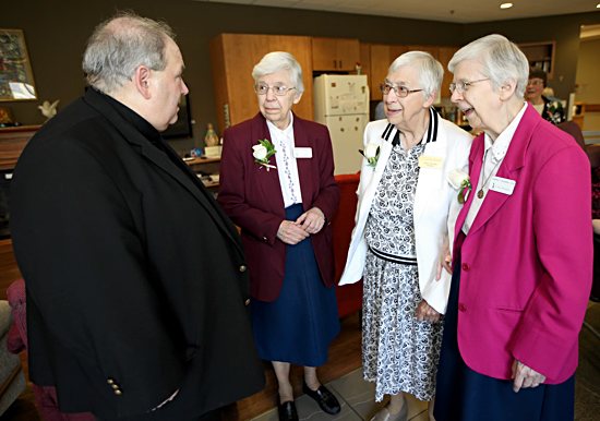 Archbishop Bernard Hebda talks with Benedictine Sisters Andriette, left, Rosella and Andrine Schommer June 22 after celebrating Mass to mark the 70th anniversary of St. Paul’s Monastery in Maplewood.