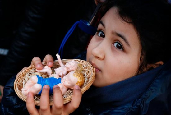 A girl in St. Peter's Square holds baby Jesus figurines for Pope Francis to bless during his Angelus at the Vatican. Children observed an annual tradition by bringing their Nativity figurines for the pope to bless. 