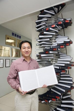Scientist He Jiankui poses Aug. 4, 2016, with "The Human Genome," a book he edited, for a photo at his company, Direct Genomics, in Shenzhen, China. An ethicist calls Jiankui's gene editing on a human embryo "a train wreck of a thing to do." 