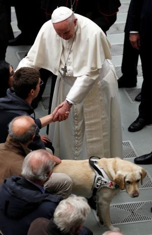 Pope Francis greets a visually impaired man during his general audience in Paul VI hall at the Vatican Dec. 19.