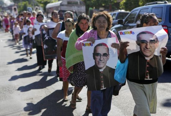 People hold posters showing the image of St. Oscar Romero during a 2014 protest in San Salvador, El Salvador. The protest was against the decision of the mayor to name a street after deceased Army Maj. Roberto D'Aubuisson, allegedly the mastermind of the 1980 killing of St. Romero.