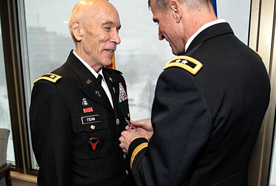Father Jerome Fehn receives the Legion of Merit Medal Dec. 1 from Major General Neal Loidolt, deputy adjutant general of the Minnesota National Guard, at Joint Force Headquarters of the Army and Air National Guard in the Minnesota State Capitol in St. Paul.