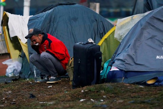 A Venezuelan migrant brushes his teeth outside his tent at a makeshift camp Nov. 26 in Bogota, Colombia. The United Nations estimates there are more than 258 million migrants around the world living outside their country of birth.