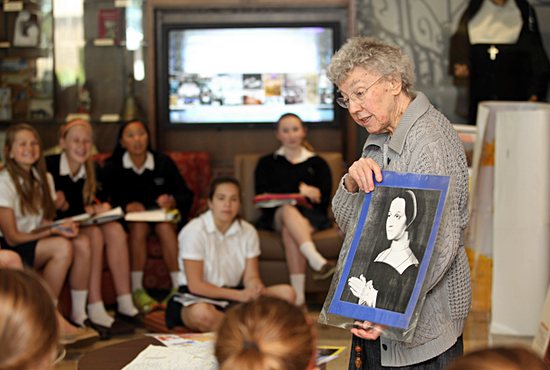 In this archive photo, Visitation Sister Mary Paula McCarthy talks to a ninth-grade religion class at Visitation School in Mendota Heights about the history of her order. She is holding a picture of one of the co-founders, St. Jane Frances de Chantal. 