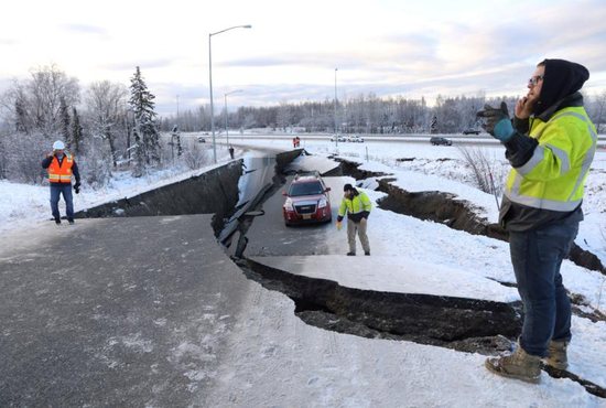 First responders stand on a collapsed roadway near the airport after a magnitude 7.0 earthquake Nov. 30 in Anchorage, Alaska.