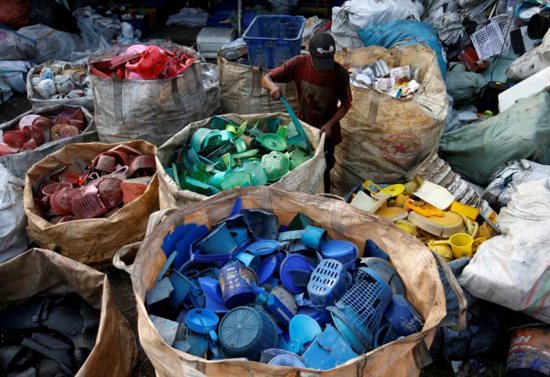 A worker sorts used plastic in 2018 at a recycling center in Jakarta, Indonesia. Months after Indonesia's military was summoned to unclog Jakarta Bay, Archbishop Ignatius Suharyo joined a chorus of disapproval of the nation's growing plastic waste problem by calling parishioners to action.