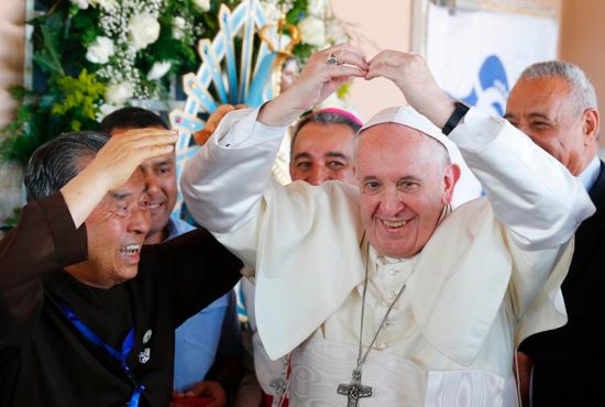 Pope Francis makes the shape of a heart as he visits Casa Hogar el Buen Samaritano (Good Samaritan Home) in Panama City Jan. 27, 2019. At left is Father John Oh Woong-Jin.