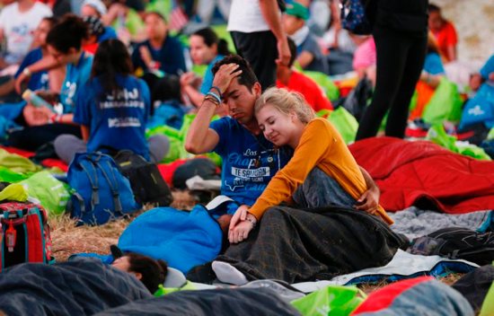 A couple wake up before Pope Francis' celebration of Mass for World Youth Day pilgrims at St. John Paul II Field in Panama City Jan. 27, 2019. 
