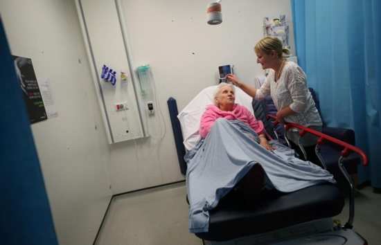 Sarah Plant comforts her grandmother, Barbara Lant, who awaits treatment at Milton Keynes University Hospital in England June 26, 2018. "If we had to pay for health care, we wouldn't have been able to afford it. I don't really want to think about what it would have been like," said Plant. 