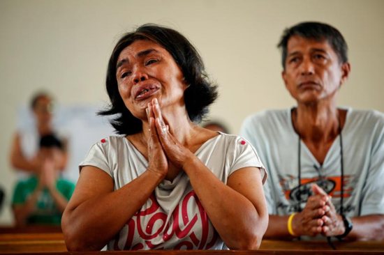 A woman prays during Mass at a church in Tacloban, Philippines, Nov. 17, 2013. The Philippines, with about 80 million Catholics, is the epicenter of the church in Asia and has seen more public cases of sexual abuse against both minors and women and in recent years than other Asian countries. 