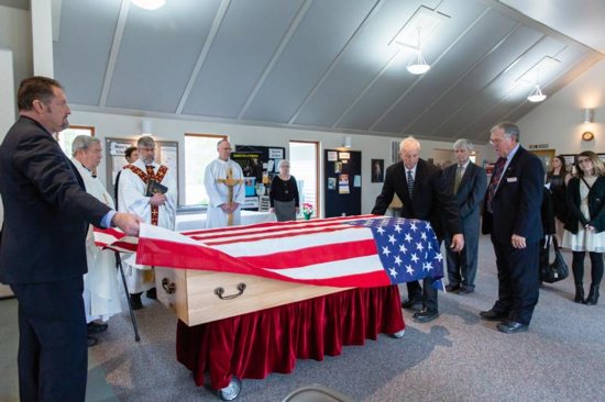 An American flag is lifted from the casket of U.S. Navy Capt. Rosemary Mariner at St. Joseph Church in Norris, Tenn., as Msgr. Bill Gahagan, second from left, and Father Richard Armstrong, third from left, prepare to celebrate her funeral Mass Feb. 2, 2019. Mariner, who in retirement taught military history at the University of Tennessee and led a Scripture study group at a rural Knoxville parish, died Jan. 24 at age 65 after a five-year battle with ovarian cancer.