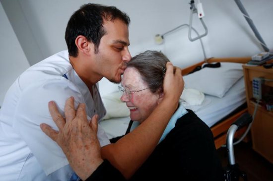 A woman in a Duesseldorf, Germany, receives a kiss from a retirement home employee Sept. 12, 2018. People cannot feel authentic compassion for others if they do not feel true love for Christ, Pope Francis said Feb. 1 during an audience with members of the Hospitaller Brothers of St. John of God.