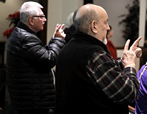 John Heinn of Andover, left, and Michael Hile of Minneapolis pray using American Sign Language at the Dec. 30 Mass. 