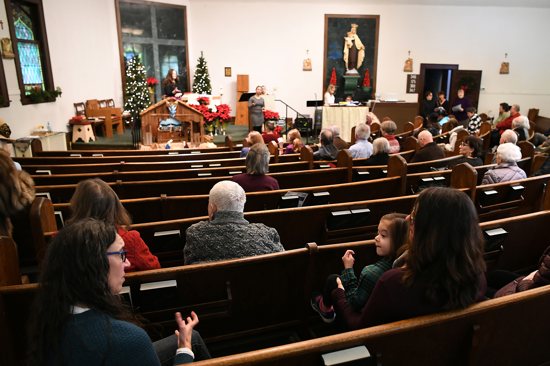 Sarah Novotny, left, uses sign language to communicate with her daughter, Audrey, 5, before Dec. 30 mass at Our Lady of Mount Carmel in northeast Minneapolis.