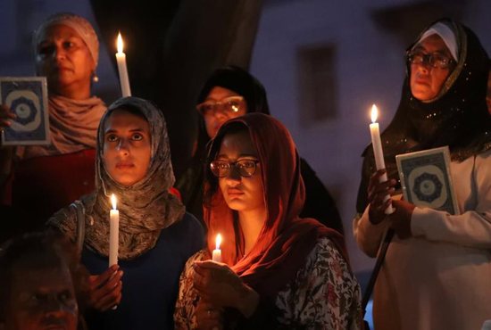 Women hold candles during a vigil outside St. George's Anglican Cathedral in Cape Town, South Africa, March 17, 2019, for the victims of the March 15 mosque attacks in Christchurch, New Zealand.
