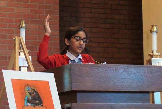 Shayla Chelliah, a sixth-grader at St. Francis International School in Hyattsville, Md., leads students in intercessory prayers March 22, 2019, during a school prayer service for victims of the New Zealand mosque shootings. Many of the speakers during the hourlong service addressed the need to put an end to hatred even in small ways at school.