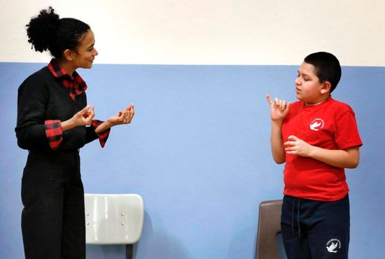 Anthony Zuniga, a fifth-grader at Children of Peace Catholic in Chicago, asks Lauren Teruel Ridloff a question using sign language Feb. 22, 2019. The actress, who is deaf, is a Tony Award nominee and currently a star of "The Walking Dead" series on AMC. She graduate in 1991 from the school, which was then called Holy Trinity School for the Deaf.