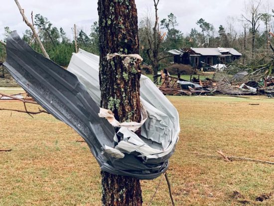A piece of metal is seen wrapped around a tree following a tornado in Beauregard, Ala., March 3, 2019. At least 23 people were confirmed dead in Lee County, Ala.