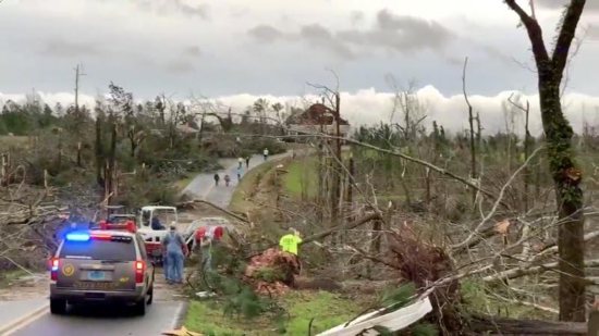People clear fallen trees and debris on a road following a tornado in Beauregard, Ala., March 3, 2019. At least 23 were confirmed dead in Lee County, Ala.