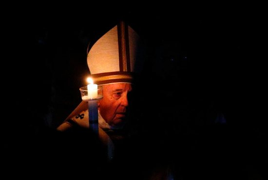 Pope Francis carries a candle in procession as he arrives to celebrate the Easter Vigil in St. Peter's Basilica at the Vatican April 20, 2019.