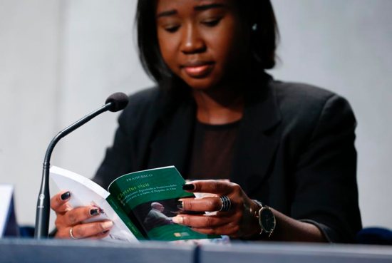 Laphidil Oppong Twumasi, a youth leader from Ghana, reads Pope Francis' apostolic exhortation, "Christus Vivit" (Christ Lives), during a news conference for its presentation at the Vatican April 2, 2019. The document contains the pope's reflections on the 2018 Synod of Bishops on young people, the faith and vocational discernment. 