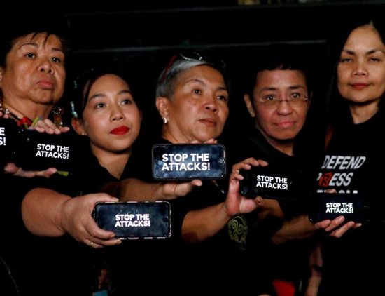 Journalists, including Rappler CEO Maria Ressa, raise their smart phones with words "STOP THE ATTACKS!" in a rally for press freedom in Quezon City, Philippines, Feb.15, 2019. Church leaders across Asia have expressed alarm over threats to press freedom amid reports of increasing attacks and intimidation of journalists, resulting in growing levels of self-censorship.