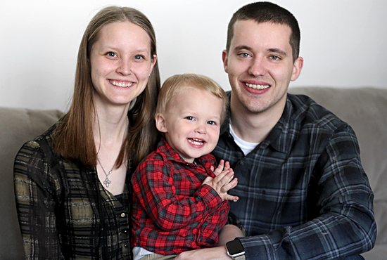 Ben Hoffman, right, smiles with his wife, Sara, and son, Jude, at his home in Cottage Grove April 20. Hoffman is a sexual abuse survivor who was victimized by former priest Curtis Wehmeyer. He’s focusing on sharing his story to encourage other survivors and people affected by the clergy abuse scandals to find their hope in Christ.