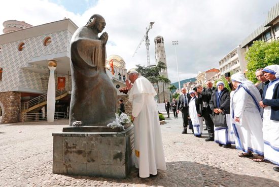 Pope Francis prays in front of a statue of Mother Teresa at the Mother Teresa Memorial during a meeting with religious leaders and the poor in Skopje, North Macedonia, May 7, 2019.