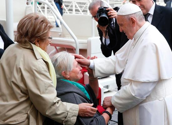 Pope Francis blesses a woman in a wheelchair during his general audience in St. Peter's Square at the Vatican May 29, 2019.