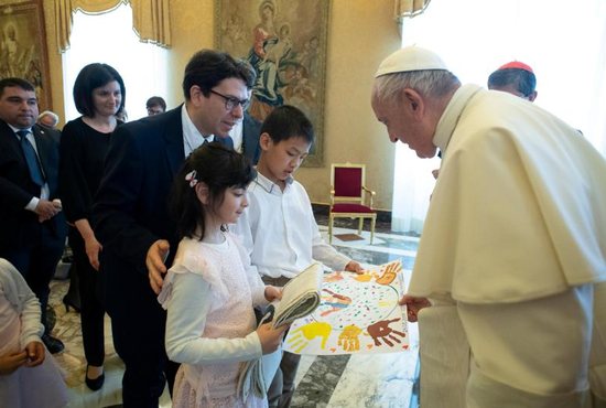 Pope Francis talks with young people during an audience with a delegation from the Institute of the Innocents, a Florence-based organization dedicated to caring for children. The pope met the delegation at the Vatican May 24, 2019, during an audience marking the 600th anniversary of the Italian institute.