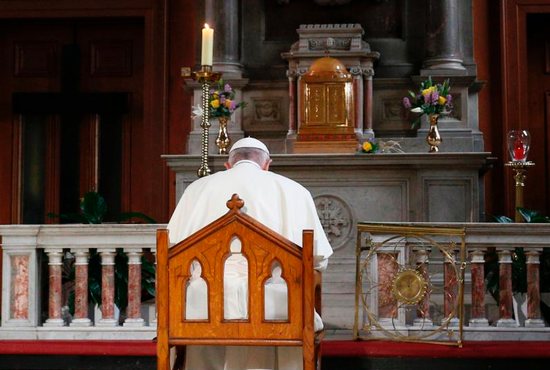 Pope Francis prays in front of a candle in memory of victims of sexual abuse as he visits St. Mary's Pro-Cathedral in Dublin Aug. 25, 2018. Pope Francis has revised and clarified norms and procedures for holding bishops and religious superiors accountable in protecting minors as well as in protecting members of religious orders and seminarians from abuse. 