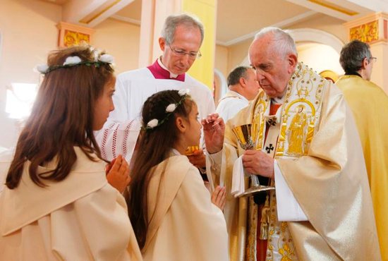Pope Francis gives first Communion to children during a Mass at the Church of the Sacred Heart in Rakovski, Bulgaria, May 6, 2019.