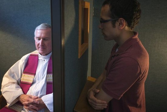 Father Timothy J. Mockaitis, pastor of Queen of Peace Catholic Church in Salem, Ore., and penitent Ethan K. Alano of Salem demonstrate how a confession is conducted May 3, 2019.