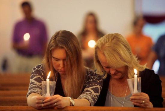 Women attend a June 1, 2019, prayer vigil for the victims of a shooting at the municipal government complex in Virginia Beach, Va. In the wake of the May 31 mass shooting that left 12 people dead in Virginia Beach, the chairman of the U.S. bishops' Committee on Domestic Justice and Human Development called for American society to examine why such violent incidents continue to occur. 