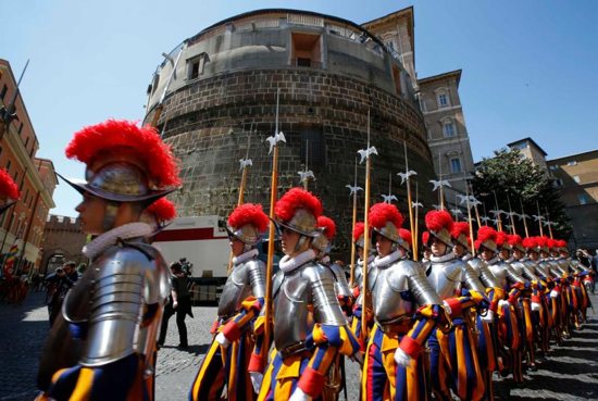 In this 2014 file photo, recruits of the Vatican's Swiss Guard march in front of the tower of the Institute for Works of Religion. The institute, often referred to as the Vatican bank, made a profit of 17.5 million euros (about US$19.8 million) in 2018, just over half the profit reported in the previous year, according to its annual report.