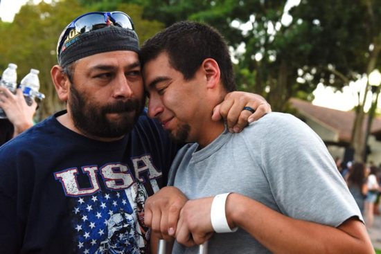 Justin Bates, right, a survivor of the Gilroy Garlic Festival mass shooting, is comforted by his father, Rob Bates, during a candlelight vigil outside Gilroy City Hall in California July 29, 2019. The event honored those that died and were injured during the shooting a day earlier. The Diocese of San Jose held a bilingual prayer vigil July 29 for victims, survivors and first responders at St. Mary Church in Gilroy in response to the shooting that claimed three lives and injured 12 others.