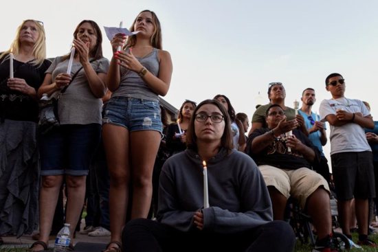 People attend a candlelight vigil outside Gilroy City Hall in California July 29, 2019, honoring those that died and were injured during a mass shooting at the Gilroy Garlic Festival a day earlier. The Diocese of San Jose held a bilingual prayer vigil July 29 for victims, survivors and first responders at St. Mary Church in Gilroy in response to the the shooting that claimed three lives and injured 12 others.