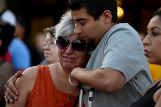Justin Bates, a survivor of the Gilroy Garlic Festival mass shooting, and his mother, Lisa Barth, attend a candlelight vigil outside Gilroy City Hall in California July 29, 2019. The event honored those who died and were injured during the mass shooting at the fesitval a day earlier. The Diocese of San Jose held a bilingual prayer vigil July 29 for victims, survivors and first responders at St. Mary Church in Gilroy in response to the the shooting that claimed three lives and injured 12 others.