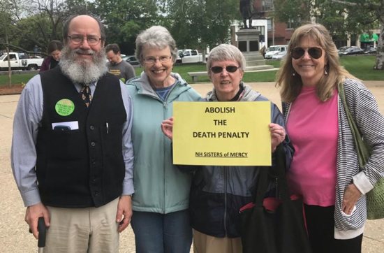 Mercy Sister Mary Ellen Foley holds a sign while standing other members of the New Hampshire Coalition to Abolish the Death Penalty