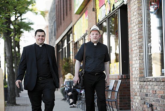 Fathers Spencer Howe and Byron Hagan walk down Central Avenue in Northeast Minneapolis