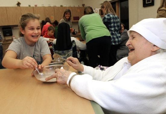 A religious sister shares a laugh with a girl at the Sorrowful Mother retirement home in Oshkosh, Wis.