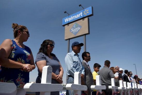 People stand near crosses Aug. 5, 2019, in honor of the victims of a mass shooting Aug. 3 at a Walmart store in El Paso, Texas.
