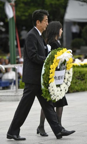 Japanese Prime Minister Shinzo Abe carries a wreath for the victims of the 1945 atomic bombing