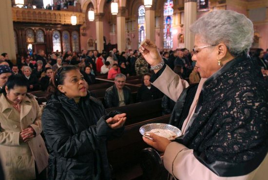 An extraordinary minister of holy Communion in Brooklyn, N.Y., distributes the Eucharist during Mass