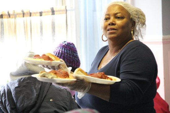 Elaine Nelson, food service manager at Mercy Hospice in Philadelphia, dishes out hot plates of spaghetti and meatballs to guests
