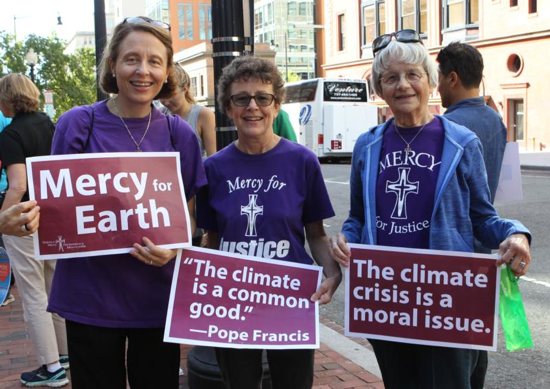 Mercy Sister Aine O'Connor, Marianne Comfort, justice coordinator for the Mercy Sisters, and Mercy Sister Rita Parks, all from Silver Spring, Md., hold aloft signs
