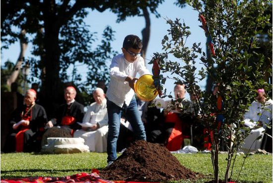 A child pours soil from different parts of the world during during a celebration marking the feast of St. Francis in the Vatican Gardens Oct. 4, 2019.