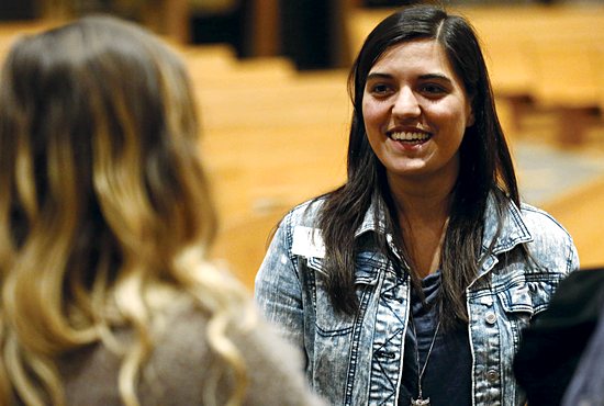 Gizzy Miko, a youth minister at St. Joseph of the Lakes in Lino Lakes, talks with people